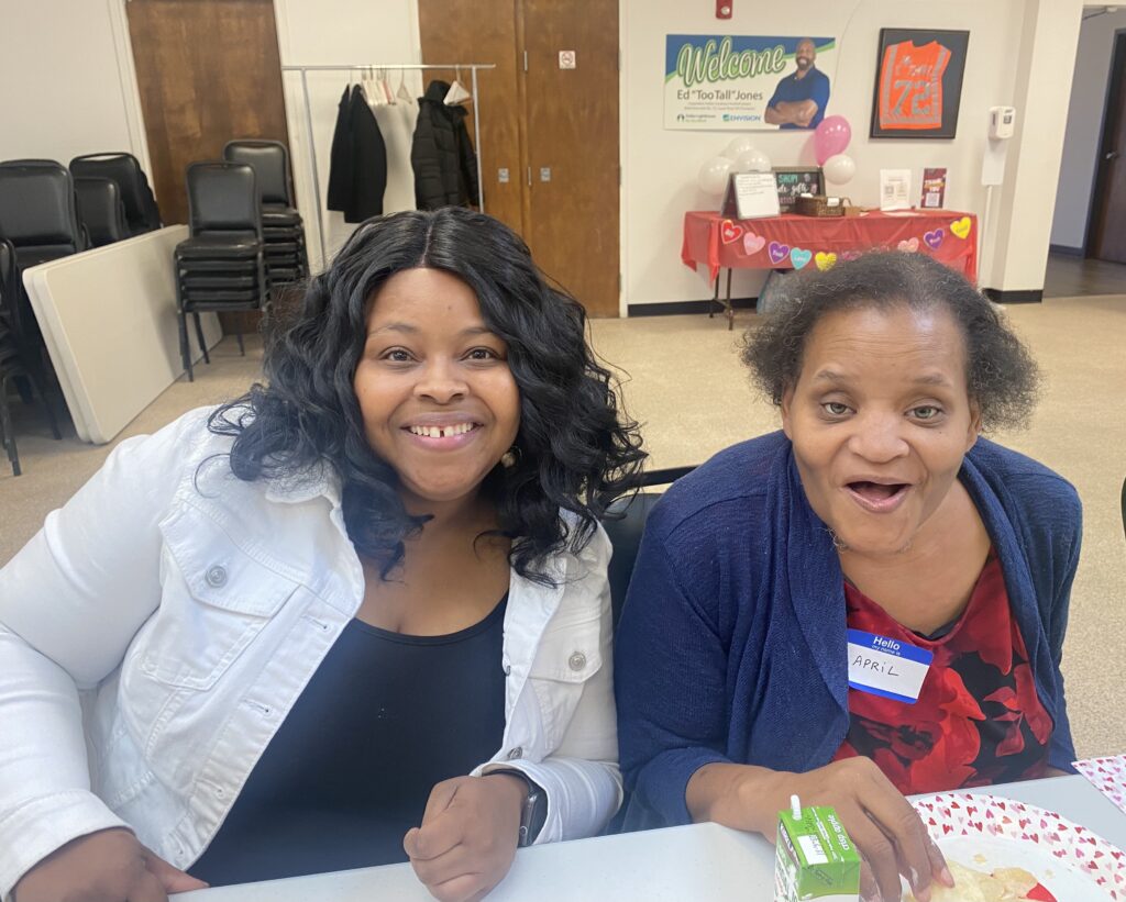 Two smiling participants sit together at a table during the Valentine’s event.